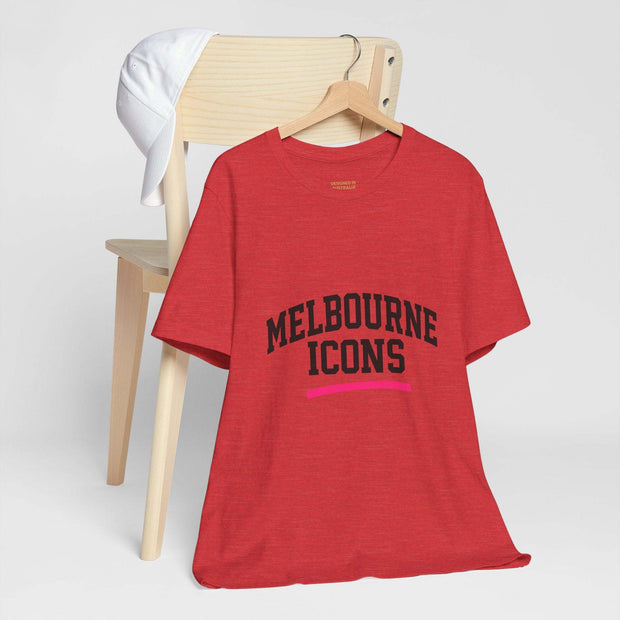 Red unisex jersey short sleeve tee with Melbourne Icons print, displayed on a wooden chair with a white cap hanging on the chair back